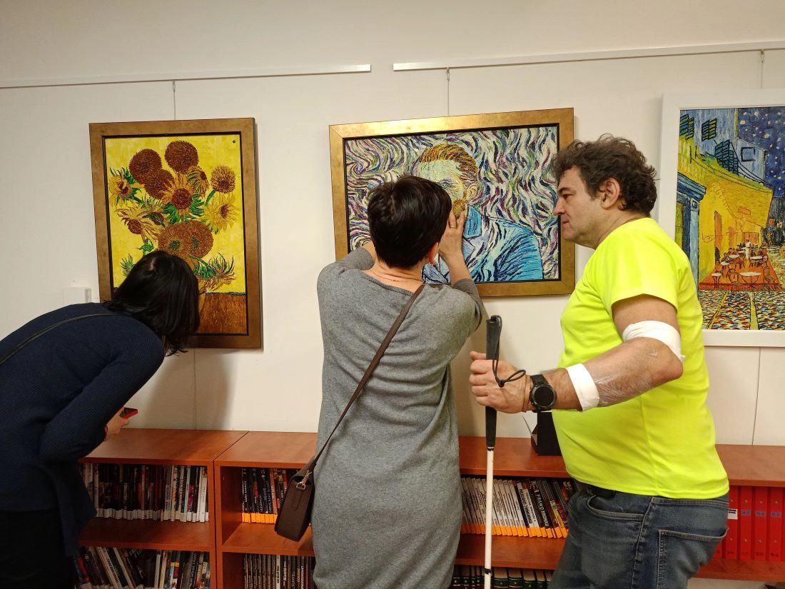 A visitor's hand interacting with an interactive wooden sculpture, demonstrating the importance of physical connection in art.